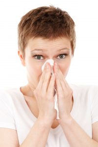 woman sneezing from winter allergies
